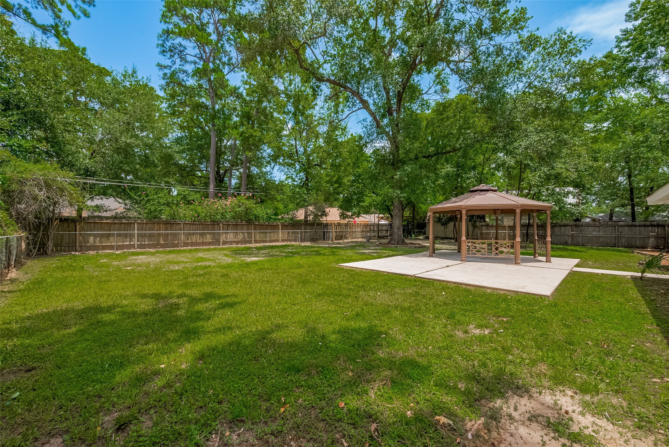 323 Spring Woods Drive Spring, TX 77386 - Photo 47 of 50 a view of a swimming pool with a table and chairs under an umbrella