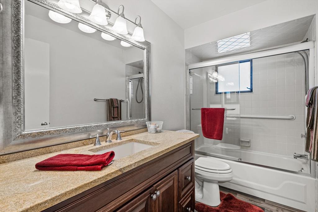 4132 Prairie View Drive Sarasota, FL 34232 - Photo 11 of 24 a bathroom with a granite countertop bathtub sink vanity mirror and toilet