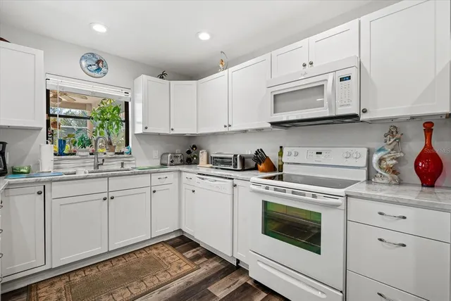 a kitchen with cabinets appliances a sink and a window