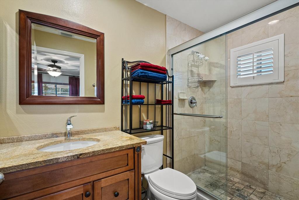 4132 Prairie View Drive Sarasota, FL 34232 - Photo 10 of 24 a bathroom with a granite countertop sink toilet and shower