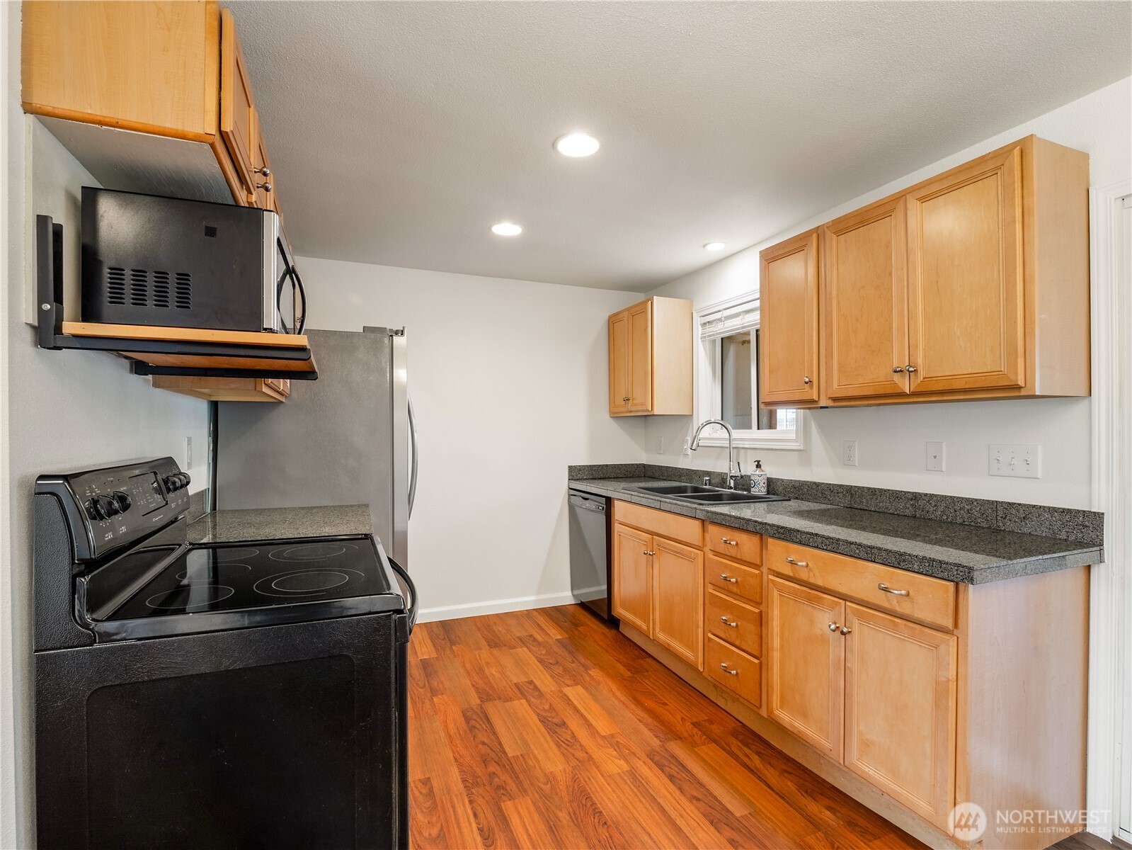 247 South D Street Buckley, WA 98321 - Photo 7 of 28 a kitchen with granite countertop a sink a stove and cabinets