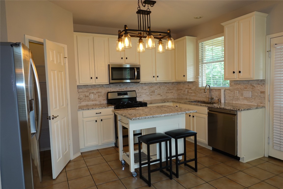 16100 South Great Oaks Drive, Unit 1902 Round Rock, TX 78681 - Photo 2 of 19 Kitchen with granite countertops, tile flooring, decorative backsplash, stainless steel appliances