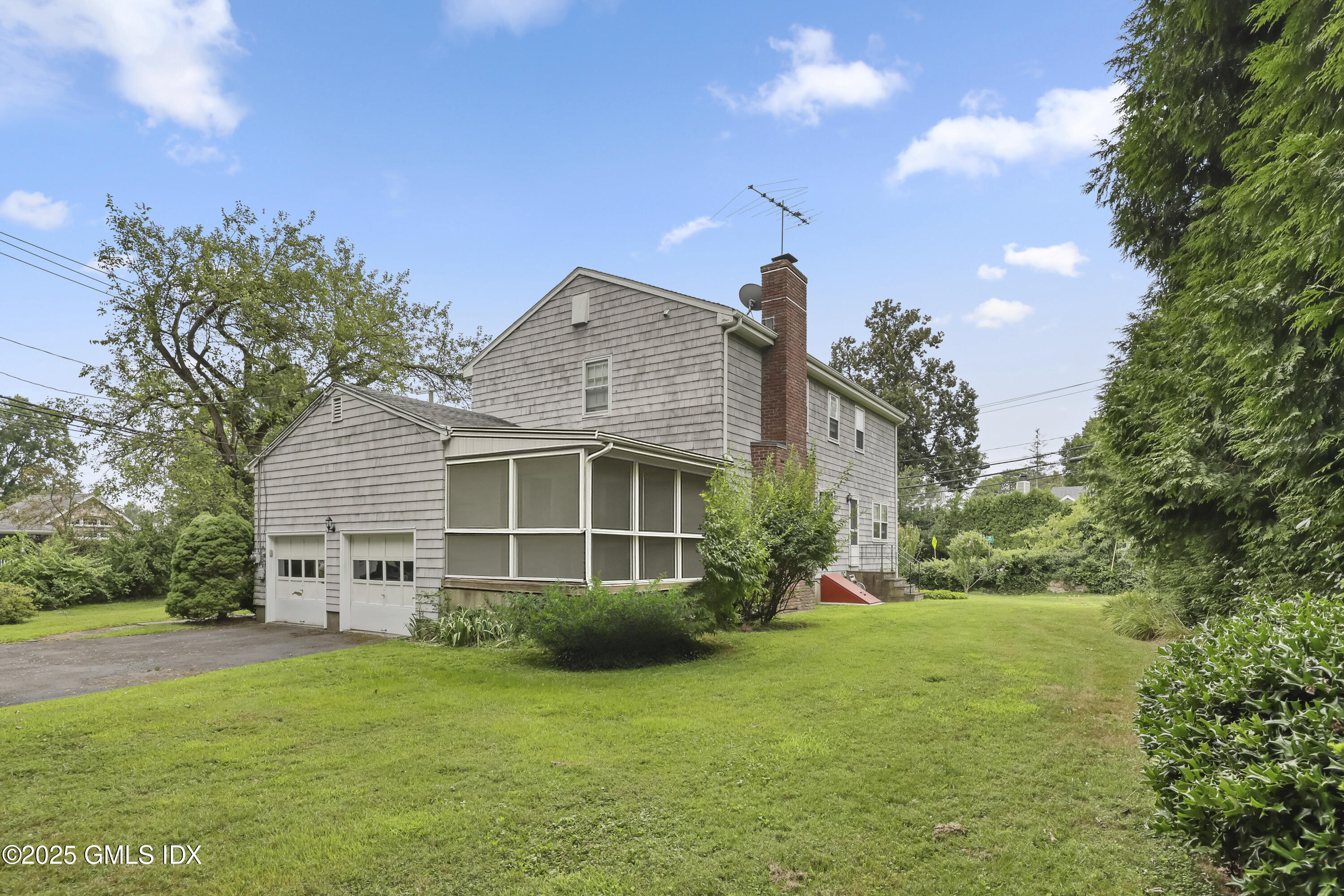 137 Shore Road Old Greenwich, CT 06870 - Photo 11 of 15 a view of a house with a big yard potted plants and large tree