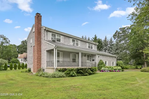 a front view of a house with a garden and plants