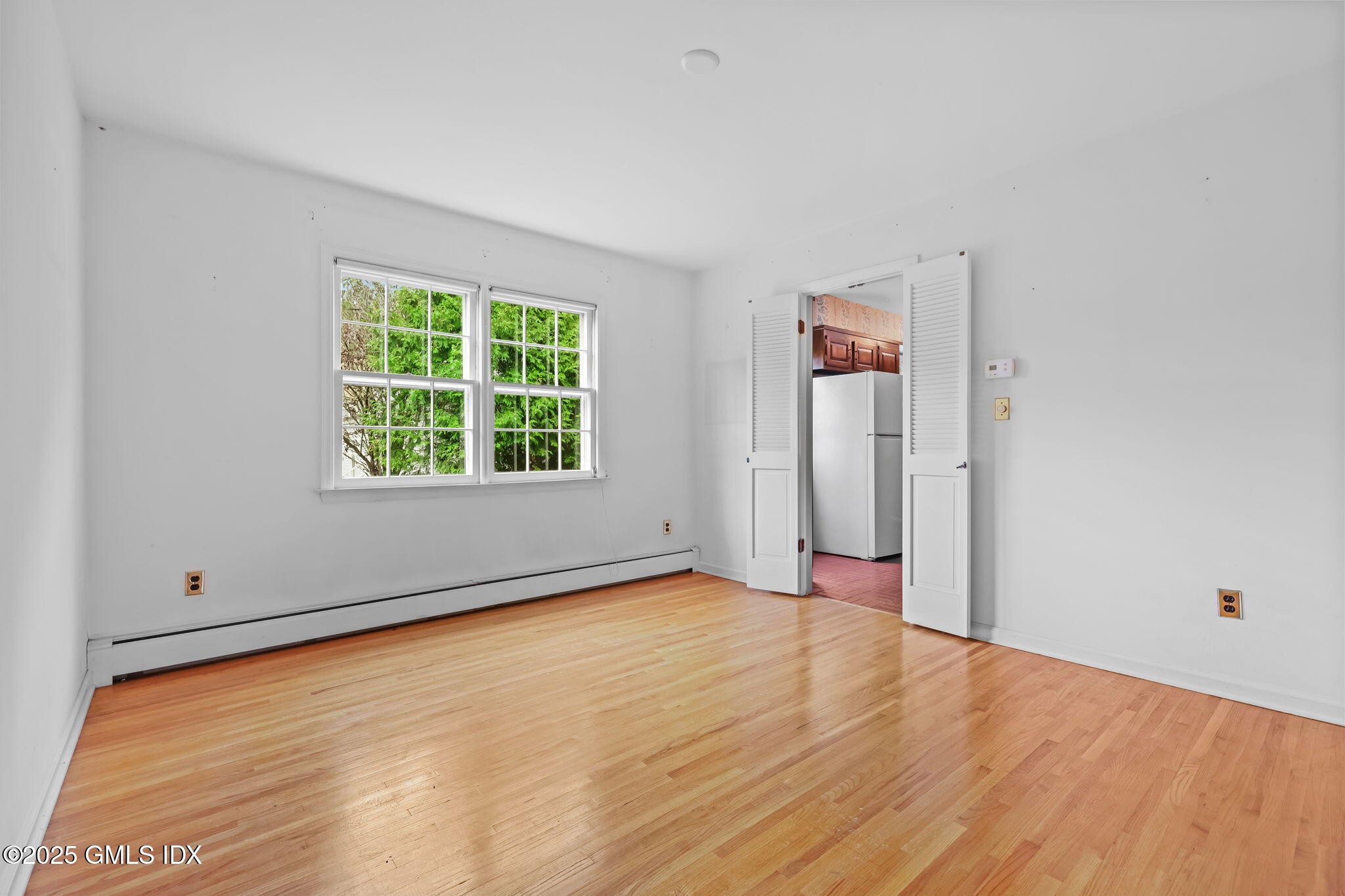 137 Shore Road Old Greenwich, CT 06870 - Photo 4 of 15 an empty room with wooden floor and windows