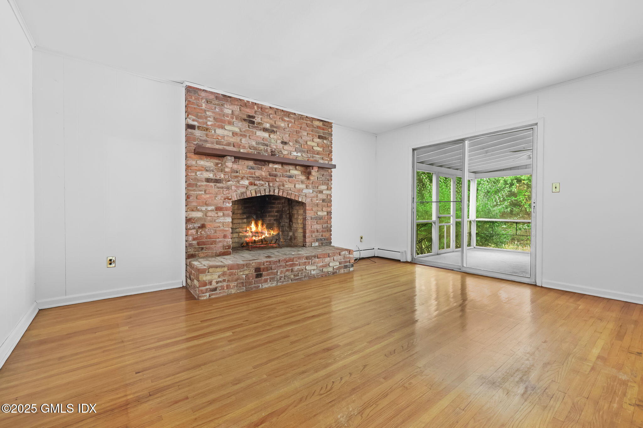 137 Shore Road Old Greenwich, CT 06870 - Photo 6 of 15 a view of an empty room with wooden floor fireplace and a window