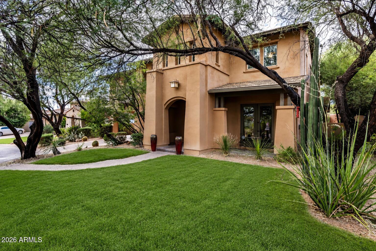 9572 East Mountain Spring Road Scottsdale, AZ 85255 - Photo 2 of 49 a view of a white house with a big yard and potted plants and trees
