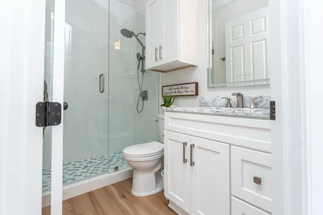 a bathroom with a sink toilet a mirror and shower