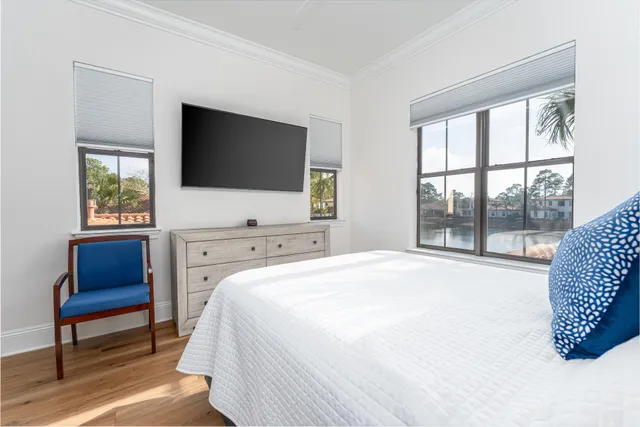 a bedroom with a bed a television and a window