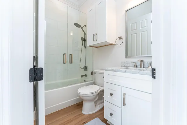 a bathroom with a sink toilet vanity and shower