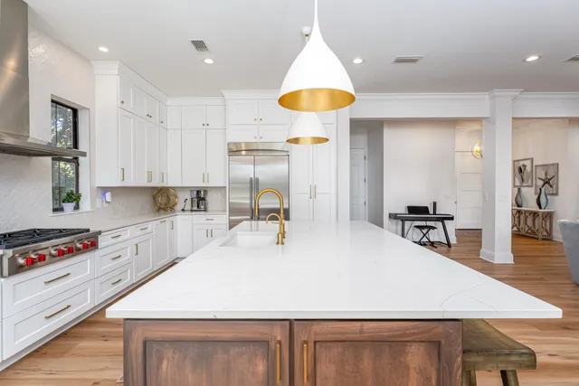 a large kitchen with kitchen island a sink a stove and a refrigerator