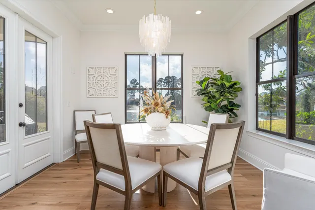 a dining room with furniture a chandelier and wooden floor