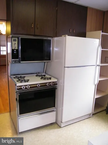 a white stove top oven sitting inside of a kitchen