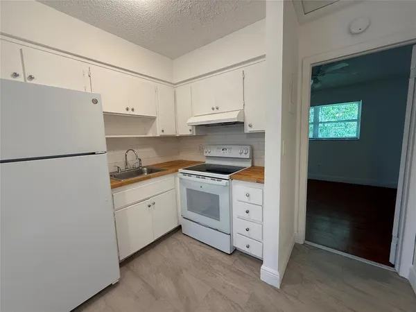 a kitchen with white cabinets and white appliances