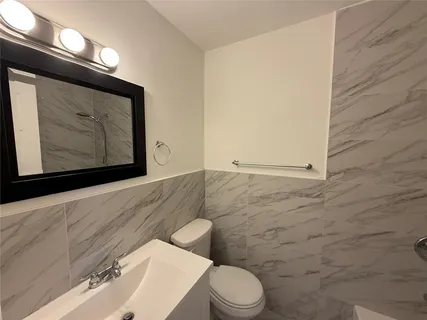 a bathroom with a toilet a sink and mirror