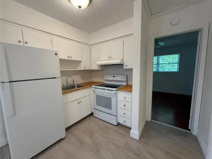 a kitchen with white cabinets and white appliances