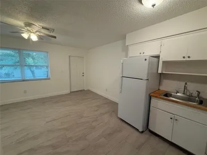a view of a kitchen with a refrigerator and cabinets