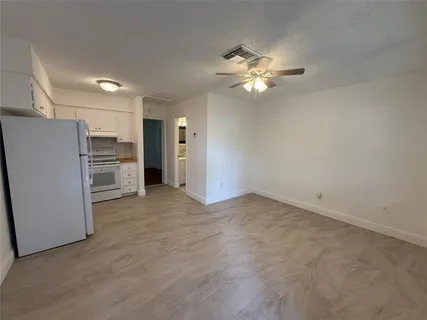 a view of a kitchen with a refrigerator a ceiling fan