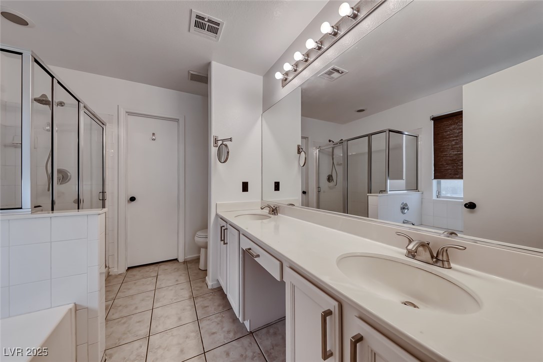 990 Ridge Path Avenue Henderson, NV 89015 - Photo 17 of 41 Full bath with a stall shower, double vanity, tile patterned floors, and a tub to relax in