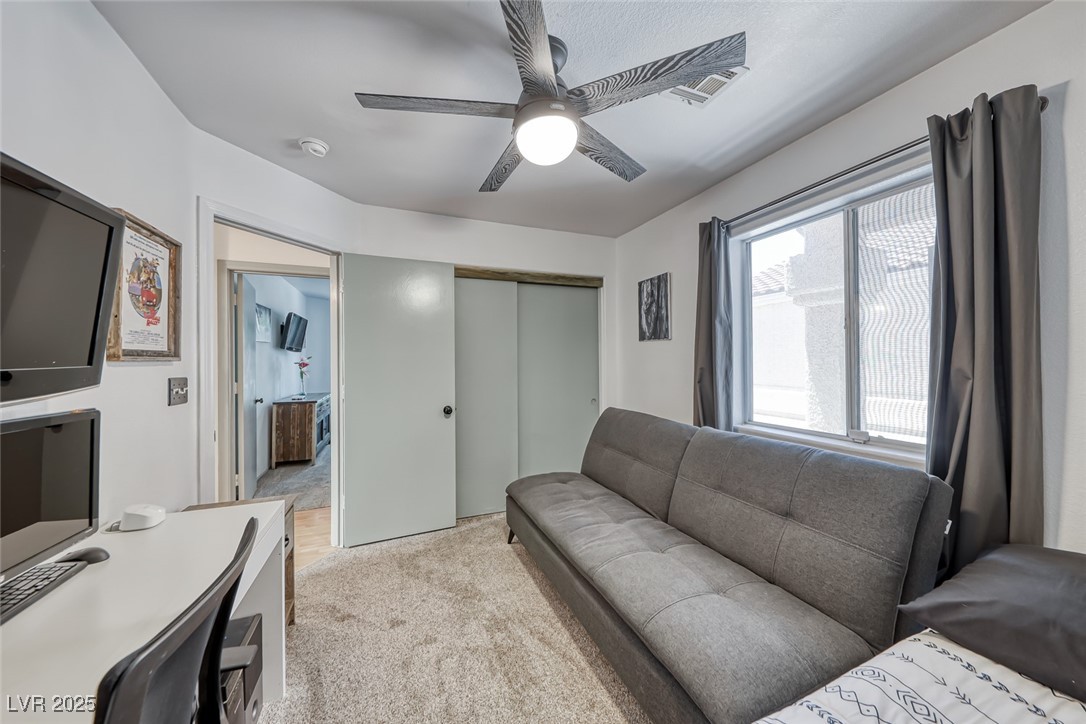 990 Ridge Path Avenue Henderson, NV 89015 - Photo 20 of 41 Living area featuring light carpet and a ceiling fan