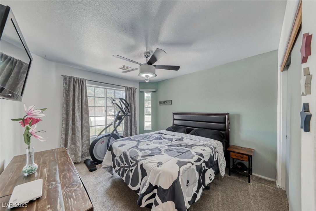 990 Ridge Path Avenue Henderson, NV 89015 - Photo 21 of 41 Bedroom with carpet floors, a closet, a ceiling fan, and a textured ceiling