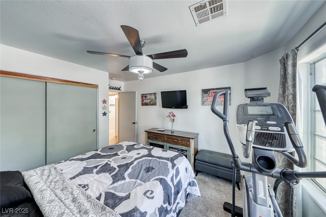 990 Ridge Path Avenue Henderson, NV 89015 - Photo 22 of 41 Carpeted bedroom with a closet, a textured ceiling, and a ceiling fan