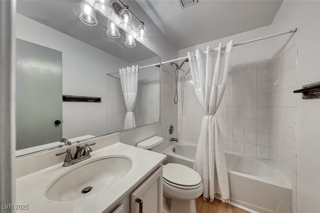 990 Ridge Path Avenue Henderson, NV 89015 - Photo 23 of 41 Bathroom featuring shower / bathtub combination with curtain, vanity, and wood finished floors