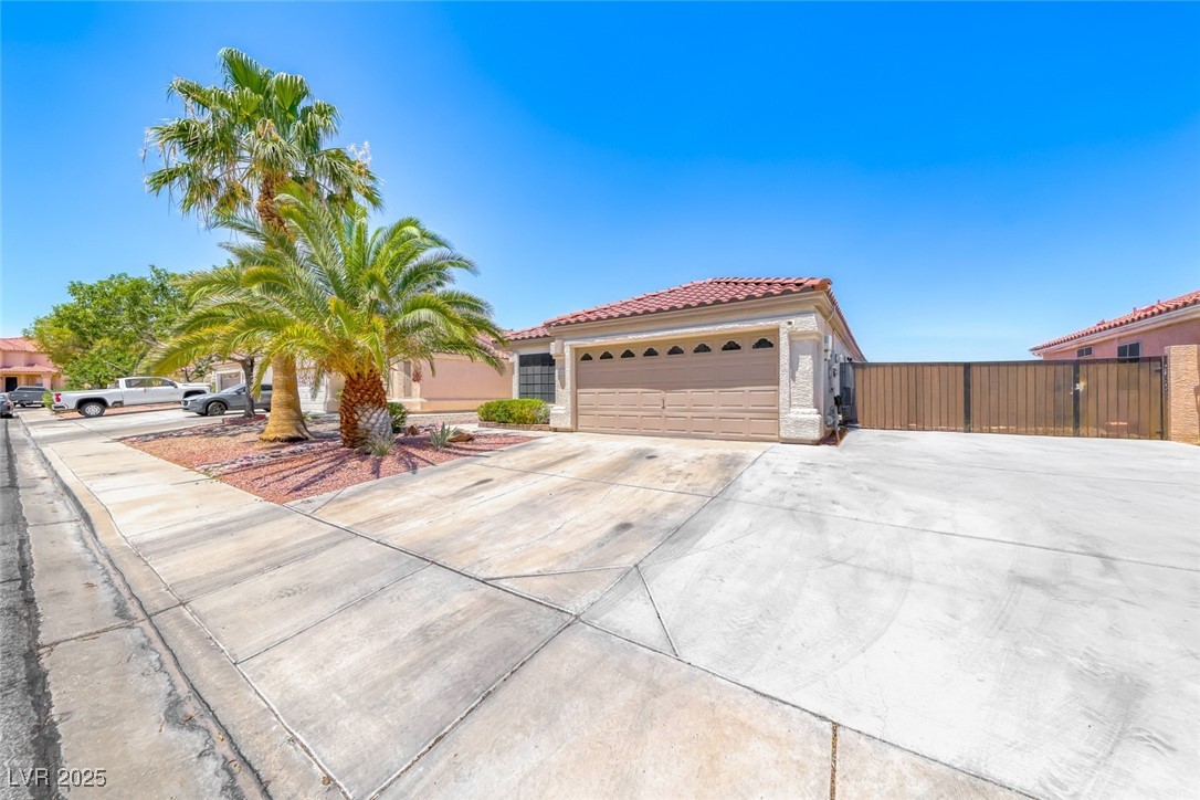990 Ridge Path Avenue Henderson, NV 89015 - Photo 3 of 41 Mediterranean / spanish-style home featuring a tiled roof, concrete driveway, stucco siding, and a garage