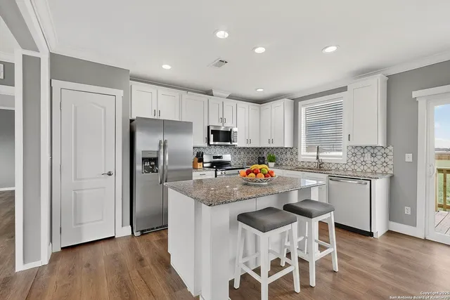 a kitchen with stainless steel appliances granite countertop a sink stove and refrigerator