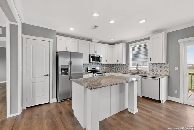 a kitchen with stainless steel appliances granite countertop a sink stove and microwave