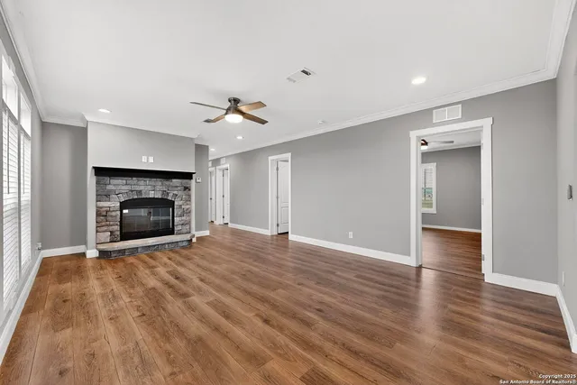 a view of empty room with wooden floor and window