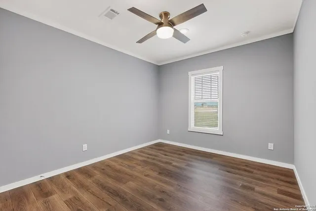 an empty room with a window and a ceiling fan