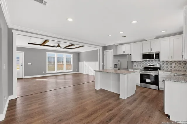 a kitchen with a refrigerator and white cabinets