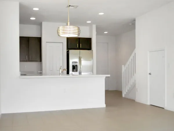 a view of a living room and kitchen with a ceiling fan
