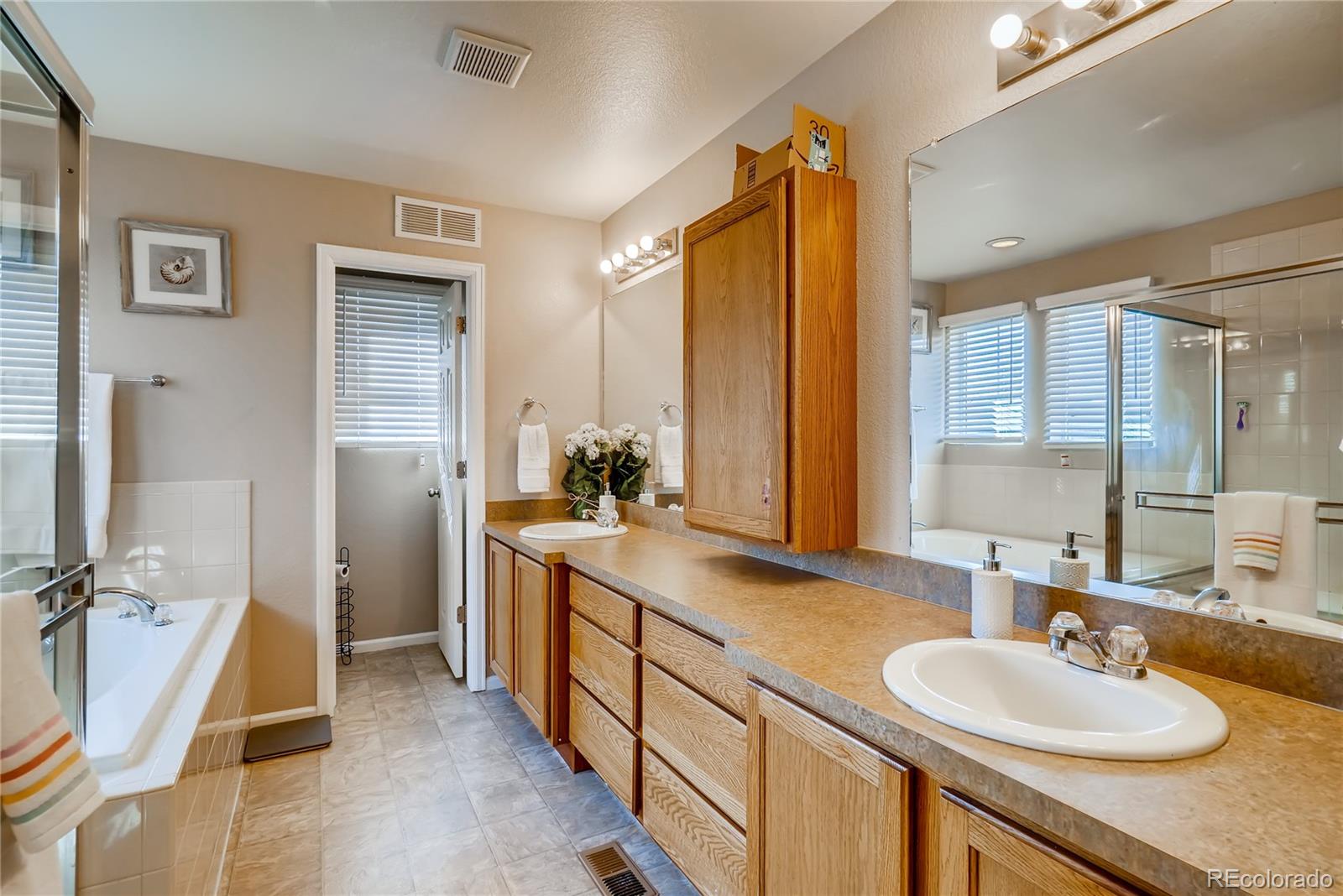 20761 Randolph Place Denver, CO 80249 - Photo 11 of 25 a bathroom with a double vanity sink a mirror and a shower