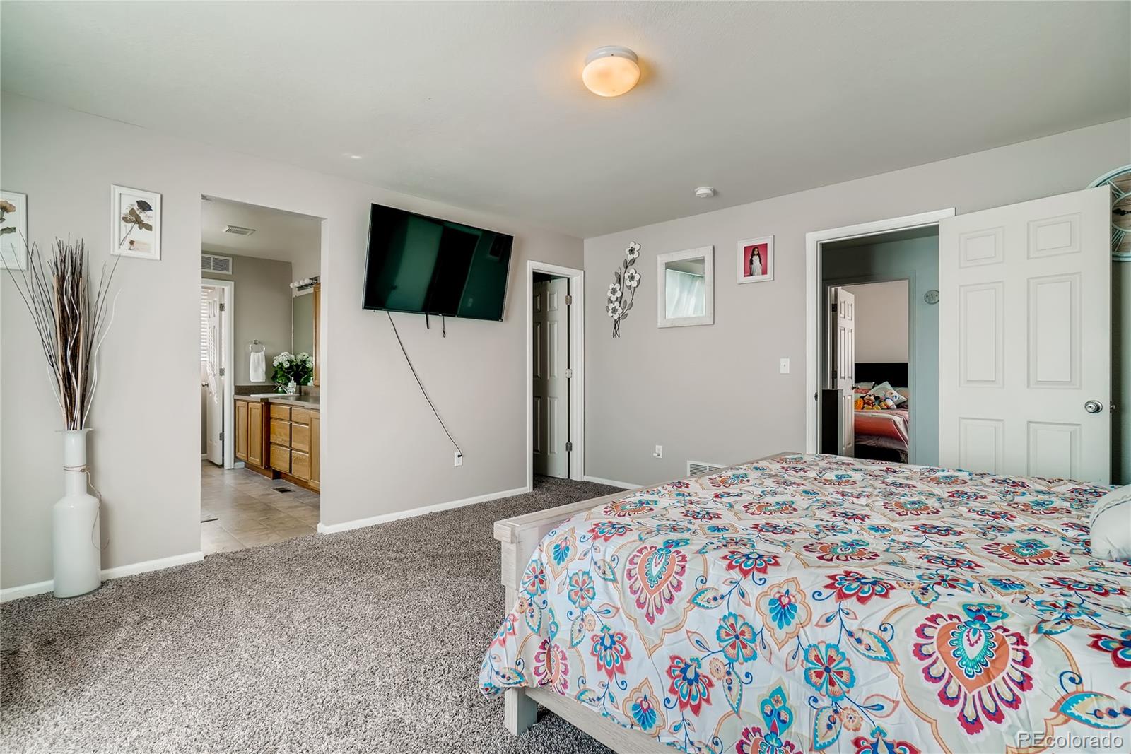 20761 Randolph Place Denver, CO 80249 - Photo 9 of 25 a bedroom with a bed and a flat screen tv