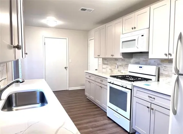 a kitchen with cabinets a sink and appliances