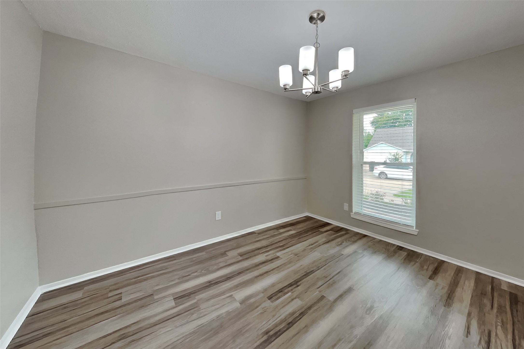 10015 Rippling Fields Drive Houston, TX 77064 - Photo 8 of 24 a view of an empty room with wooden floor and a window