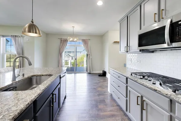 a kitchen with stainless steel appliances granite countertop a sink stove and microwave
