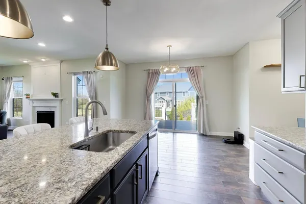 a kitchen with stainless steel appliances granite countertop a sink a stove and a wooden floors