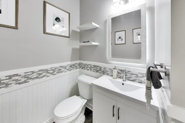a bathroom with a sink a toilet and mirror