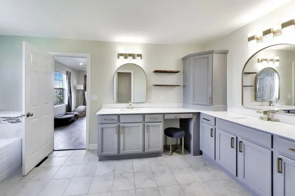 a spacious en suite bathroom with a double vanity sink and a mirror