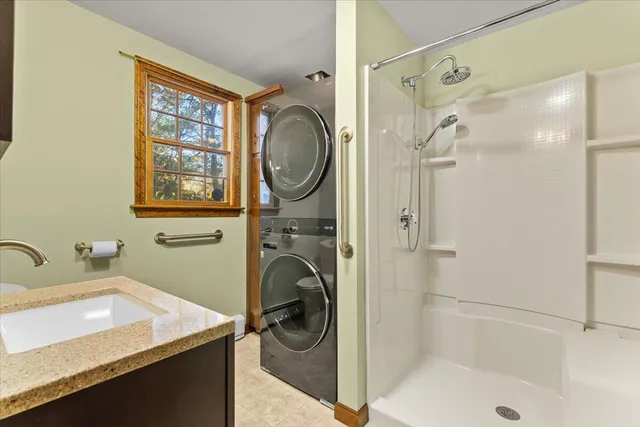 an empty room with ceiling fan and windows