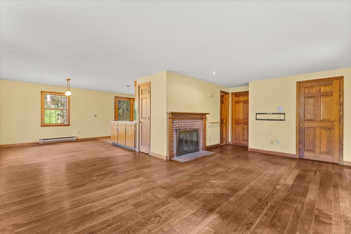 515 County Road Pocasset, MA 02559 - Photo 47 of 66 an empty room with wooden floor fireplace and windows