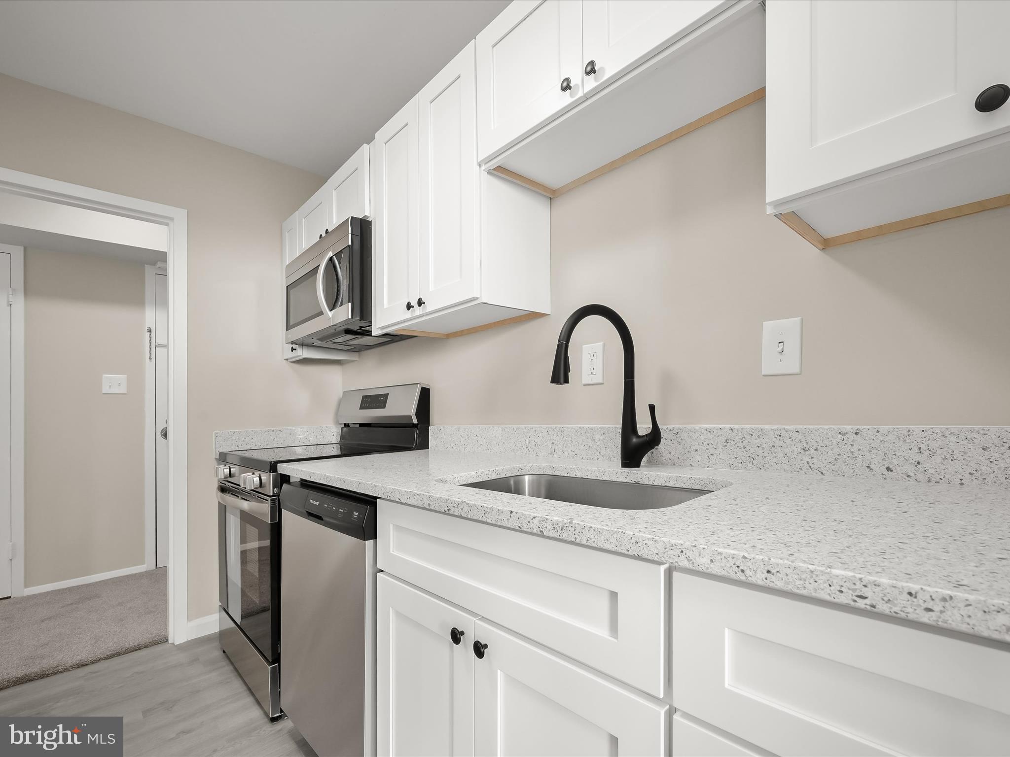 9701 Fields Road, Unit 1607 Gaithersburg, MD 20878 - Photo 10 of 42 a kitchen with stainless steel appliances granite countertop a sink and a white stove
