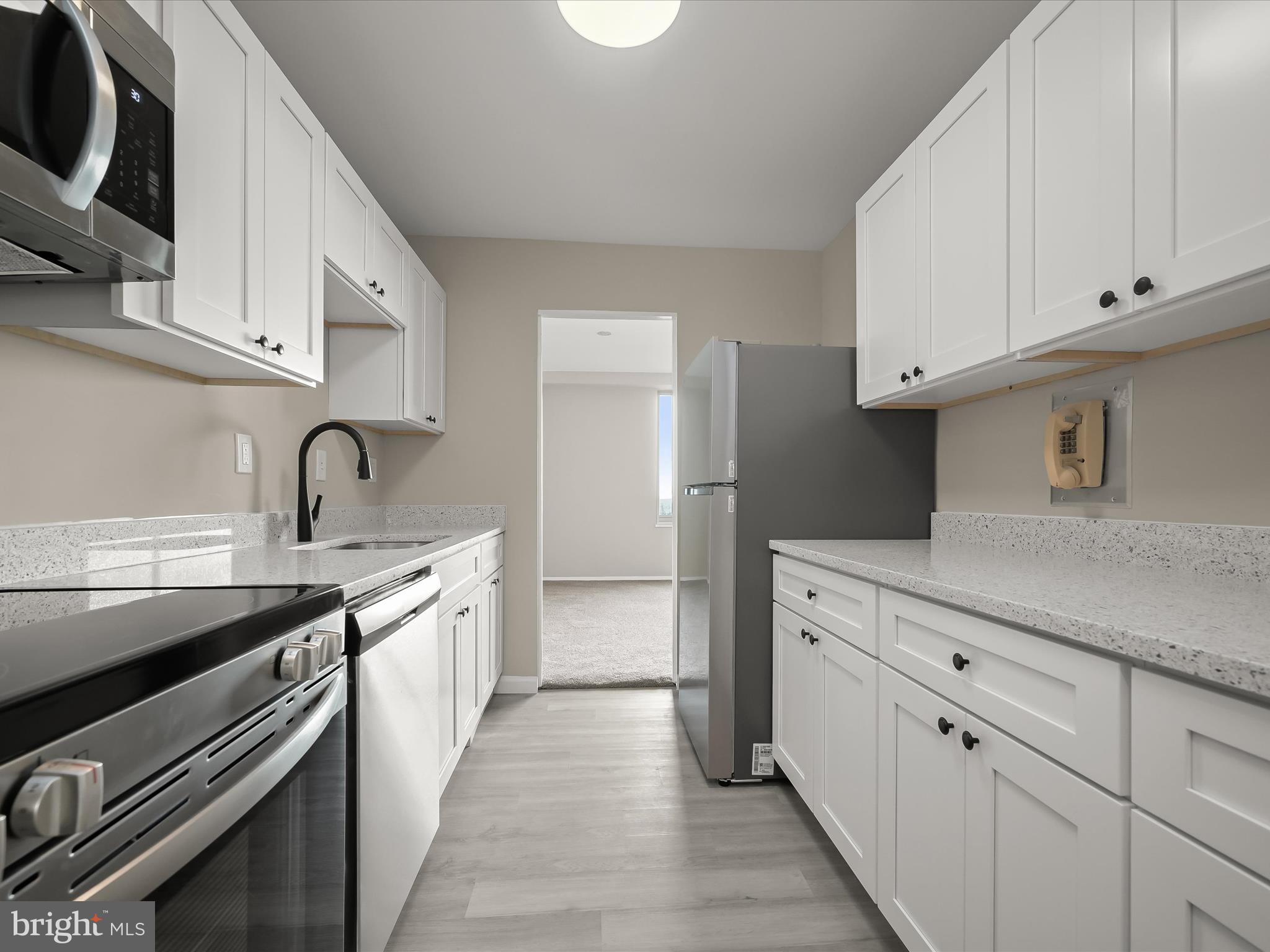 9701 Fields Road, Unit 1607 Gaithersburg, MD 20878 - Photo 2 of 42 a kitchen with granite countertop white cabinets and stainless steel appliances