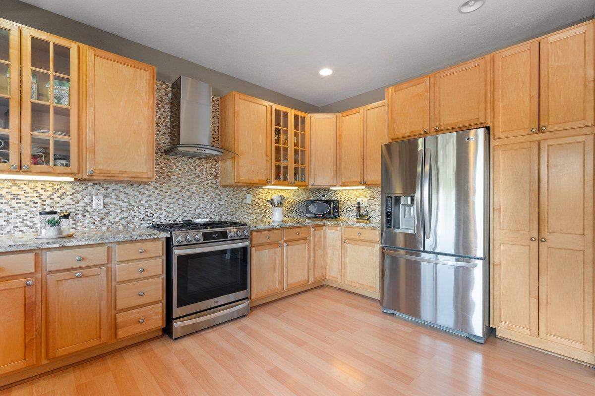 23392 Meyer Ravine Road Grass Valley, CA 95949 - Photo 11 of 58 a kitchen with granite countertop wooden floors stainless steel appliances and window