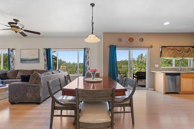 a dining room with furniture a chandelier and wooden floor
