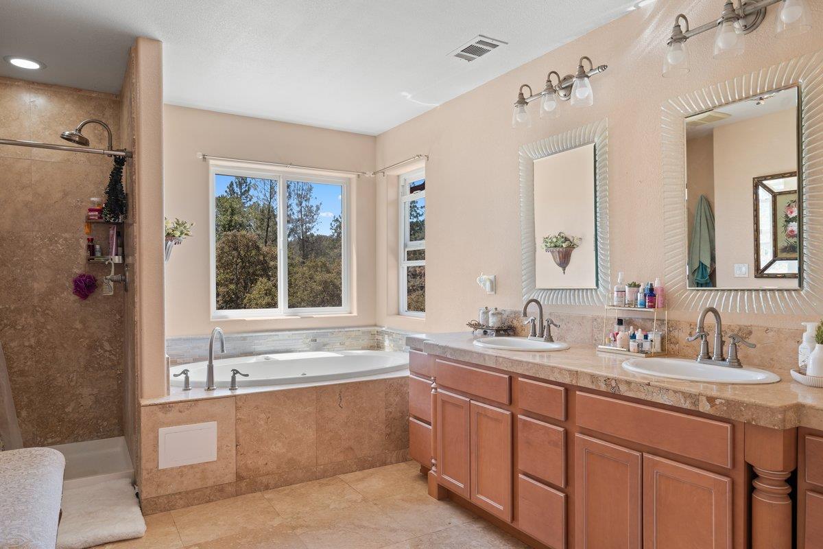 23392 Meyer Ravine Road Grass Valley, CA 95949 - Photo 19 of 58 a bathroom with a sink double vanity mirror and a bathtub