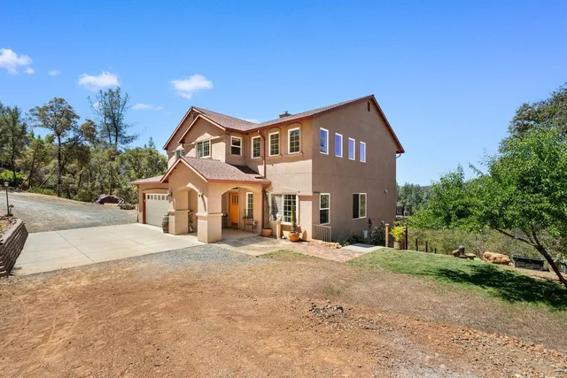 a aerial view of a house with a yard and large trees